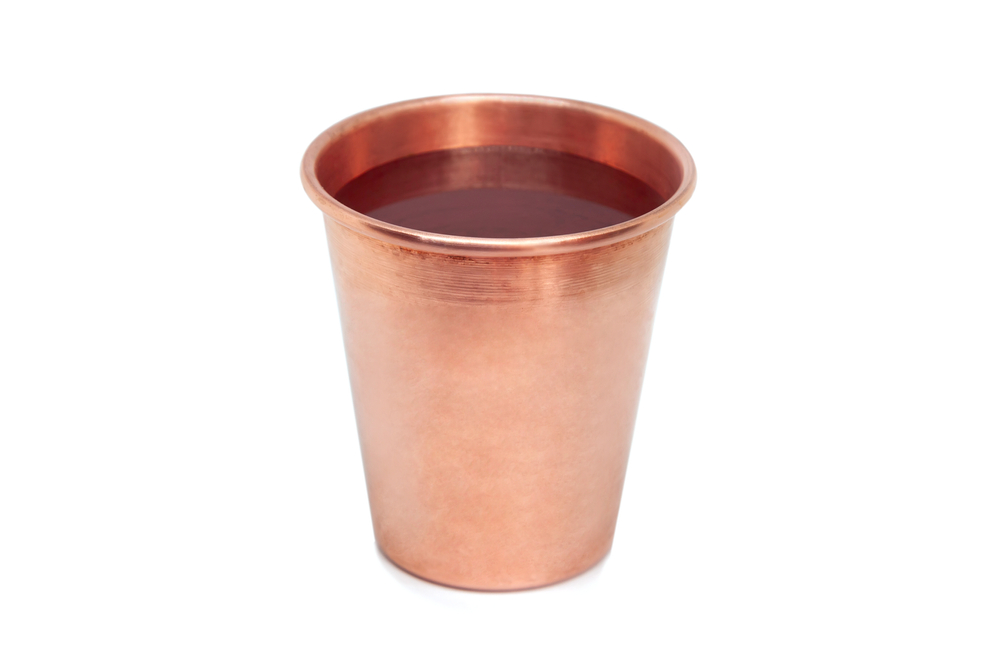Copper cup with water isolated on white background