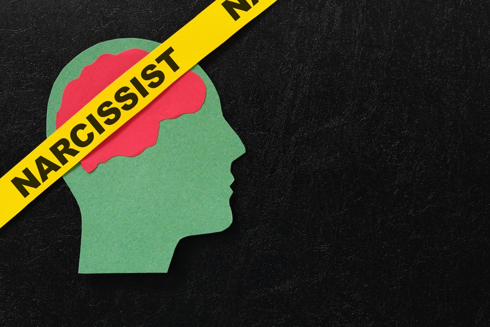 Human head profile with word narcissist in dark black background. Narcissistic behavior concept.