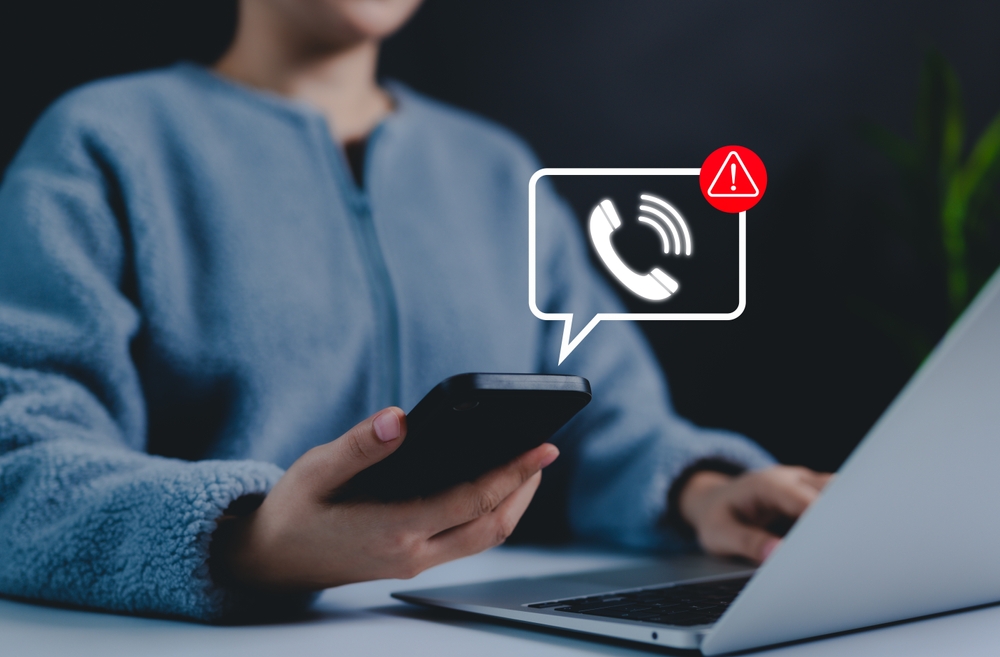 Phone scam alert notification concept. A person holding a smartphone with a digital scam warning notification, fraudulent calls, cybersecurity threats, and telecommunication security awareness. fraud,