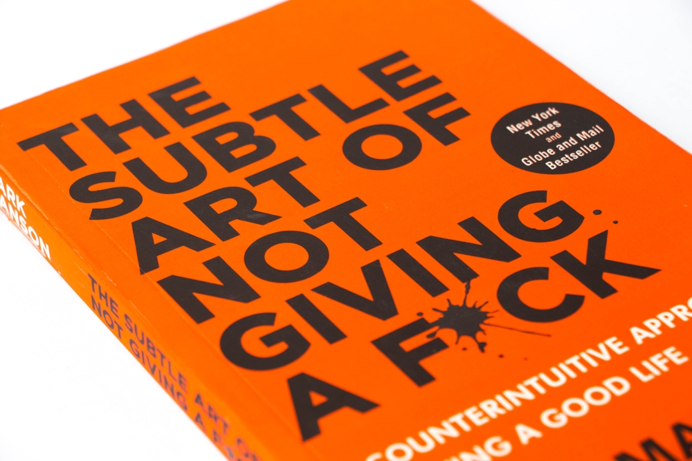 Pune, Maharashtra, India - March 20,2025.Closeup of The Subtle Art of Not Giving a Fck book written by Mark Manson. Genre - Self-help book. Isolated on white background.