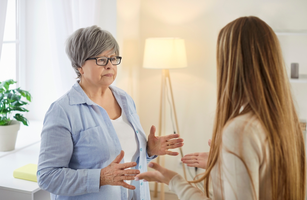 Unhappy older woman shaking and explaining something to young woman during conflict. A frustrated old mother and her eldest daughter face a misunderstanding between different generations.
