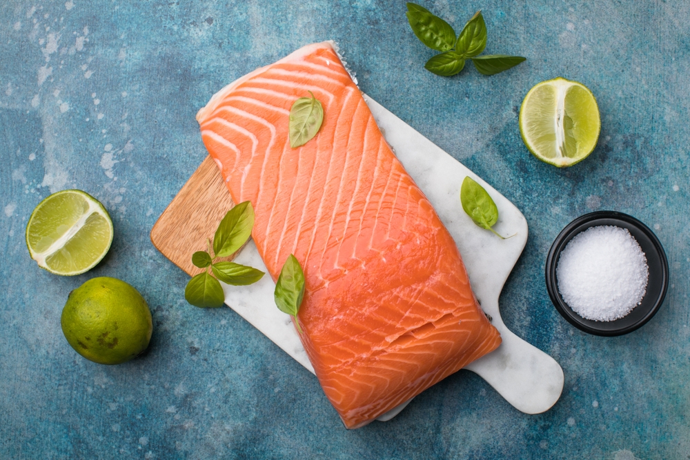 Salmon. Fresh salmon fish fillet with cooking ingredients on stone background, top view