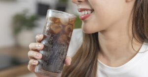 woman drinking an ice cold class of cola