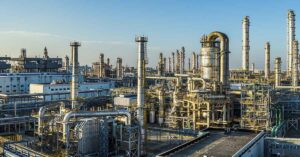 As Global Tensions Rise, Prices For These Things Are About To Skyrocket industrial oil refinery or petrochemical plant, characterized by complex piping, distillation columns, and storage tanks