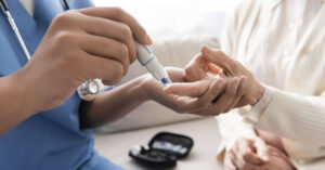 People With Severe Diabetes Cured In Trial Of A New Drug person using a glucometer to test their blood sugar level