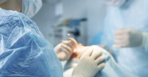 healthcare professional in a clinical setting, such as a dentist or surgeon.