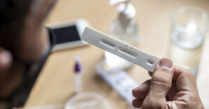 person holding COVID-19 testing kit
