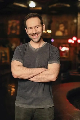 Leo Radvinsky standing and smiling with arms crossed. 
