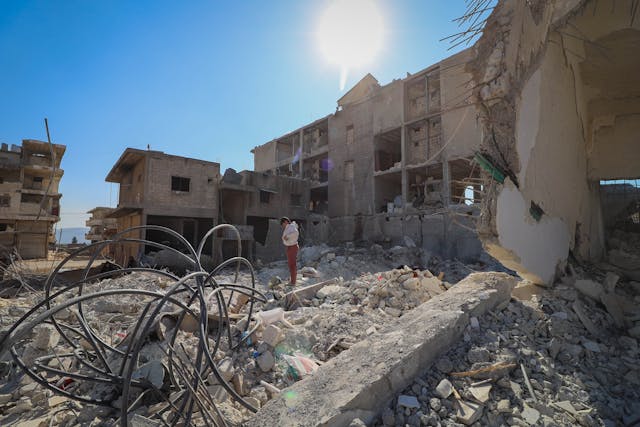 person standing in the middle of ruined buildings