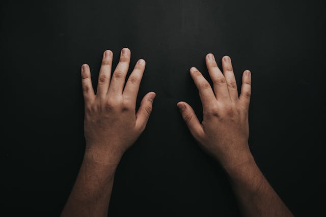 pair of hands on black background
