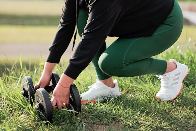 woman picking up dumbells
