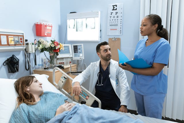 Nurse talking to patient and doctor in a hospital room