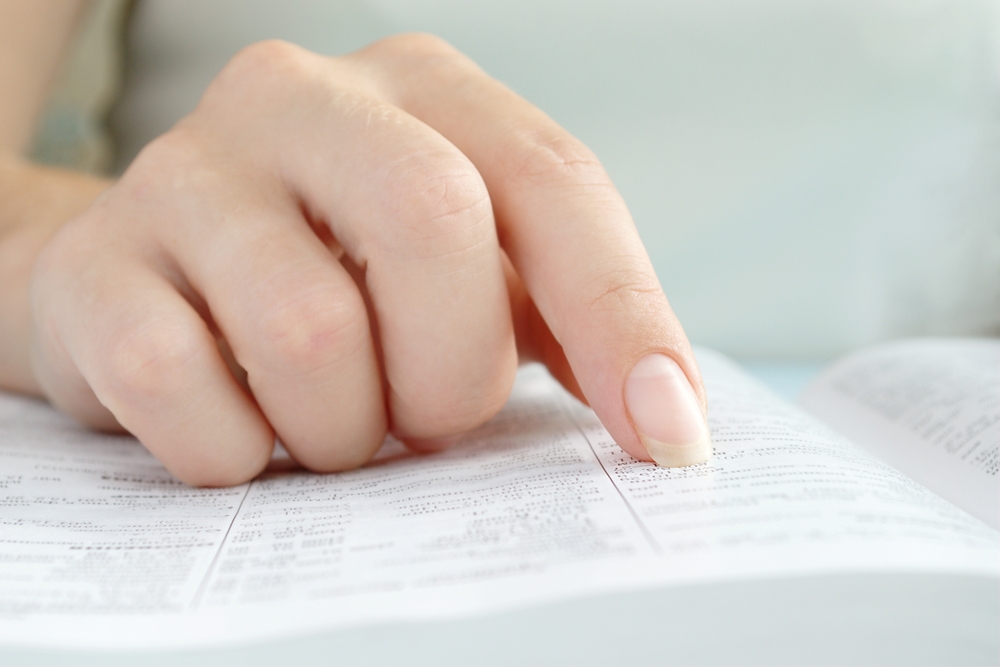 girl reading a book, shows a close-up hand and a book