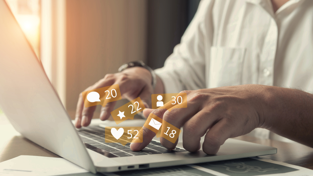 Businessman hands using a laptop with an icon social network.
