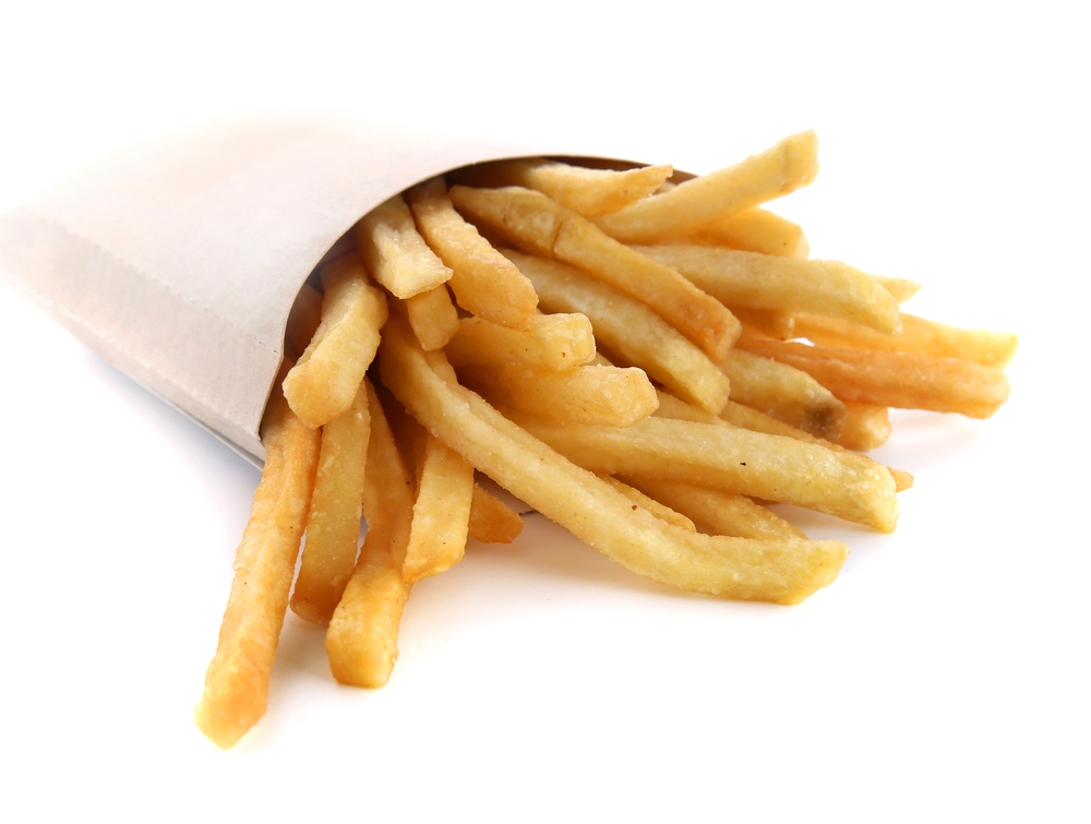French fries or fried potatoes in a carton box isolated on white background with clipping path and full depth of field