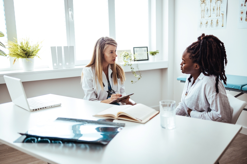 African American woman at a medical appointment with her doctor. You're well on your way back to full health stock photo. Cropped shot of an attractive young female doctor consulting