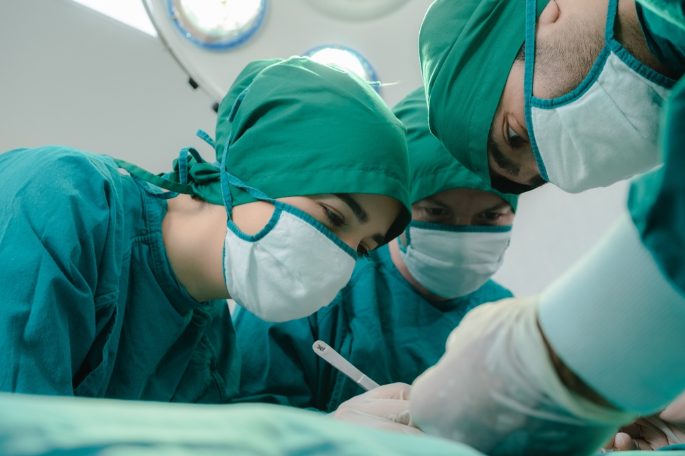 concentrated professional surgeons team during operation process in surgery by stand up through many hour surgeries, tumor cancer. surgical biopsy specimens. healthcare and medical concept.