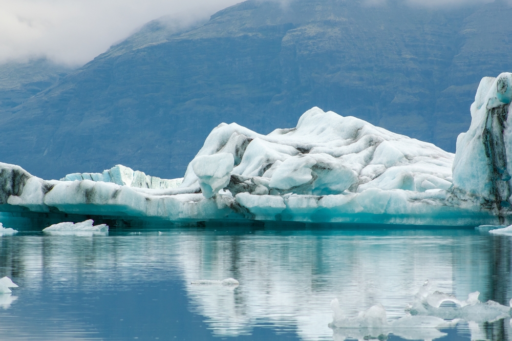 Bright blue glacial icebergs float on a serene glacial lagoon outside of Iceland's Vatnajokull National Park. 