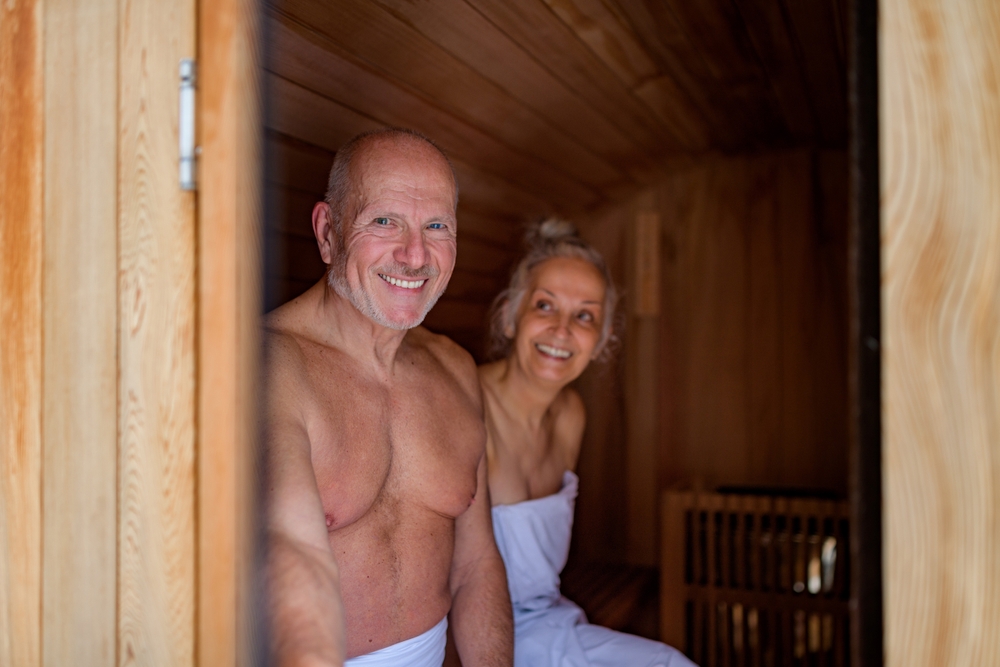 Senior couple using small sauna during cold winter day. Spa weekend getaway for elderly people.