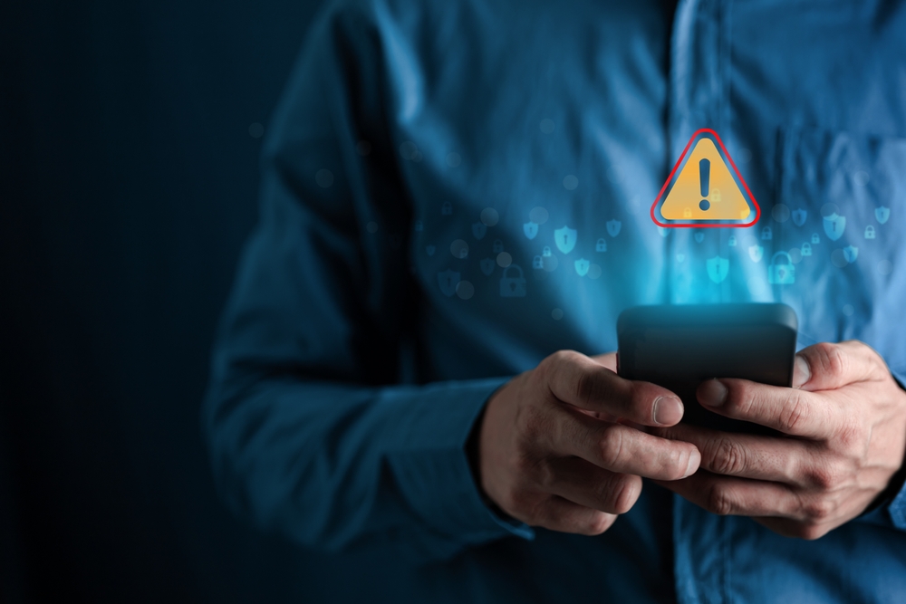 Security concept. People with warning notification and spam message icon on mobile phone