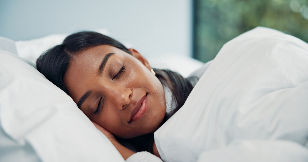 Blanket, relax and sleeping with woman in bed of hotel for comfort, peaceful nap or resting. Asleep, break and tired with Indian person in bedroom for accommodation, hospitality or lazy weekend