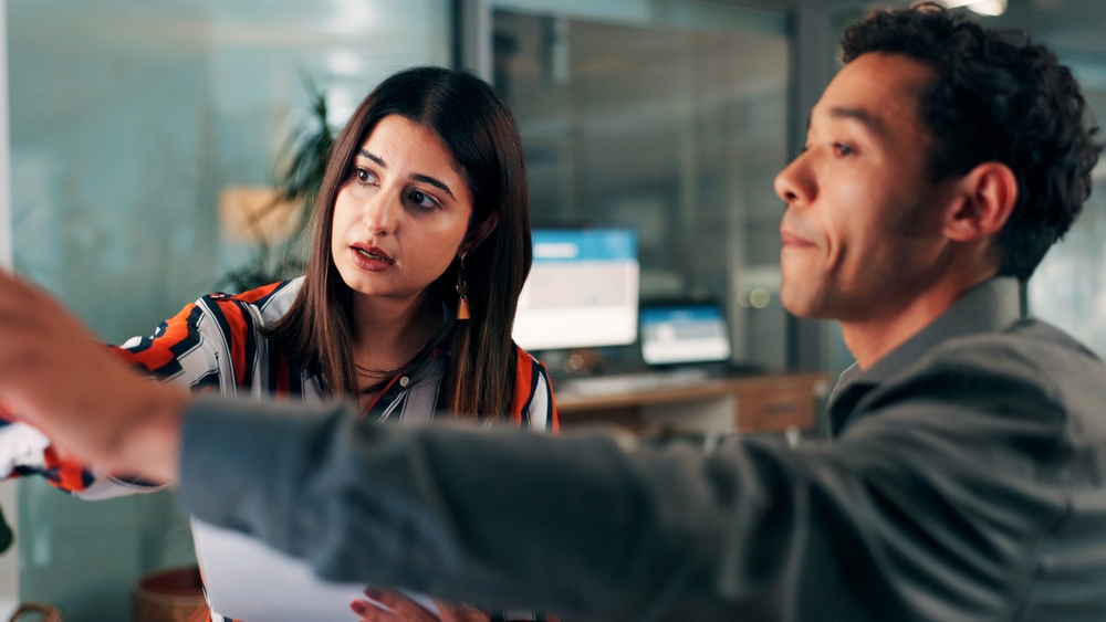 Night, review and people in office with paper, report guidance and feedback on draft article. Collaboration, help and journalist at agency with document, story ideas or blog deadline in late shift.