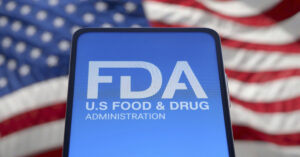 FDA logo displayed on a smartphone with American flag in background