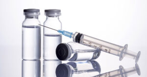 medical injection kit, featuring vials and a syringe, typically used for administering vaccines or other injectable medications