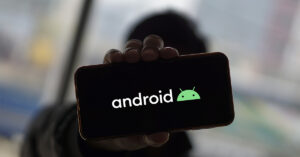 person holding up a smartphone with "Android" displayed on the screen depicting the operating system