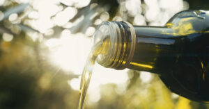 I Tried 10+ Olive Oil Brands. Here’s 5 That Don’t Suck olive oil pouring from spout of bottle, close up