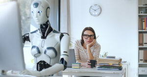 Analysis Finds AI Could Impact Over Half of U.S. Jobs Robot working on computerc with woman in the background AI taking jobs concept