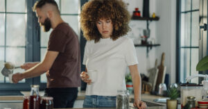 12 Behaviors That May Signal Someone Is Falling Out of Love couple in kitchen, ignoring each other