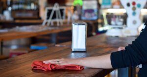 Minimum Wage Could Jump to $25 An Hour: What You Need to Know Female server waitress hand wiping cleaning restaurant table. Minimum wage job concept