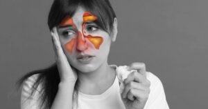 7 Overlooked Reasons You’re Always Feeling Congested, and It’s Not Just Colds And Allergies Woman suffering from sinusitis, black and white effect. Illustration on her face showing disease