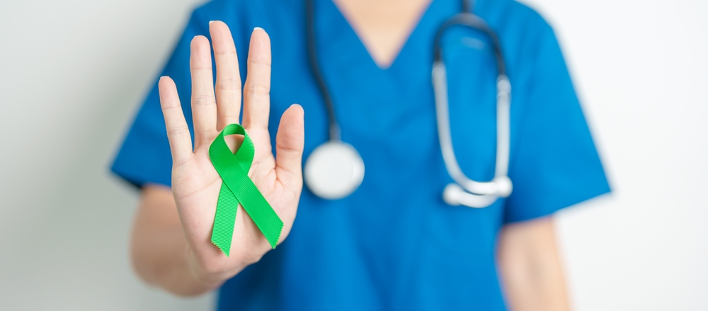 Doctor with green Ribbon for world Lymphoma Awareness September month, world Mental Health Day, Liver, Gallbladders, bile duct, cervical, kidney Cancer. Healthcare and world cancer day concept