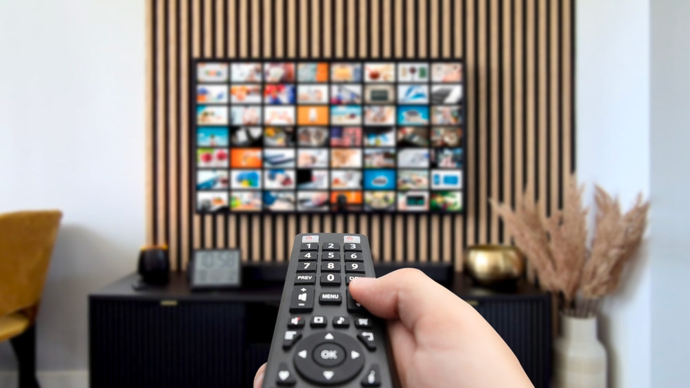 VOD multimedia TV streaming concept with hand holding remote control