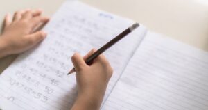 Science Finally Has an Answer for Why Most People Are Right-Handed right handed boy is doing a math homework on a desk