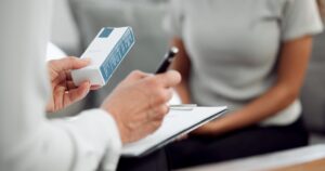 Cropped shot of an unrecognisable psychologist sitting and prescribing anti-depressants to her patient during a consultation