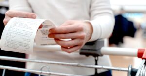 a girl with a receipt from shopping at the supermarket.
