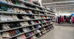 View of assorted used shoes displayed on shelves in retail thrift store. Toronto, Canada - November 26, 2025.