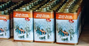 8 Things Americans Get Wrong About Canada Rows of traditional Quebec maple syrup cans displayed inside a rustic sugar shack
