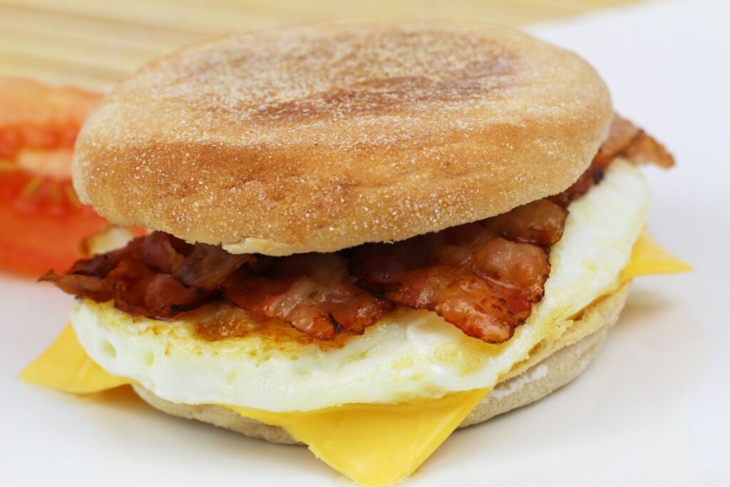 Muffin with fried egg and bacon, closeup