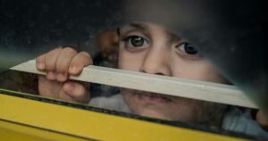 Is Your Child an 'Otrovert'? Here Are 7 Signs Parents Should Know Thoughtful child peering through a window frame in Bengaluru, India.