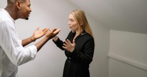 9 Gaslighting Phrases Psychologists Say Manipulators Use in Every Argument A man and woman having a heated discussion in a minimalistic indoor space.