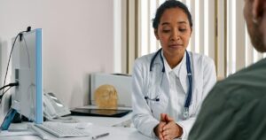 A female doctor consulting a patient in a modern medical office setting.