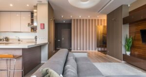 11 Surprisingly Simple Ways to Make Your Home Look Expensive Spacious living room with a modern, minimalist design and open kitchen layout.