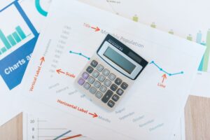 Why Draining Your 401(k) Before Claiming Social Security Could Save You Thousands Calculator placed on financial graphs and reports showcasing data analysis and business documentation.