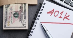 8 Costly 401(k) Mistakes Most Workers Are Still Making in 2026 A desk setup with a notebook labeled '401k', a pen, cash, and a calculator representing financial planning.