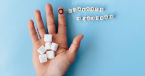 9 Diabetes Symptoms You Shouldn't Ignore — Get Checked Now A hand holding sugar cubes with 'Diabetes Symptoms' spelled out, promoting awareness.