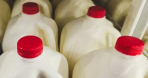 Whole Milk Is Back in Schools - Here's What Health Experts Think Jugs of whole milk with red caps